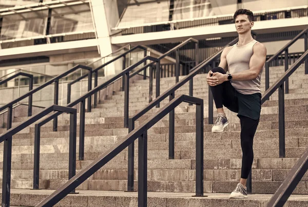 Retrato de un deportista atlético en ropa deportiva para correr. joven corredor de fitness hombre estirando las piernas antes de trotar. Calienta primero. vida sana y concepto de autocontrol. Hombre estiramiento — Foto de Stock