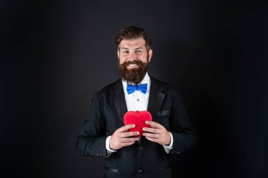 Mutlu smokinli sakallı adam romantik aşk dolu bir kalp, mutlu sevgililer günü