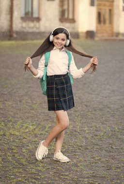 İngilizceyi her yerden öğren. Küçük çocuk kulaklık takıyor. İngilizce öğrenme kursları. Mutlu kız İngilizce öğreniyor. Dinleme becerileri. İngiliz edebiyatı ve dil bilgisi. Dil okulu