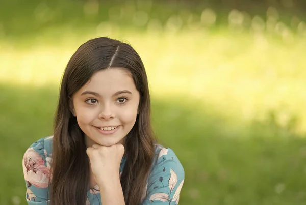 Little girl with long hair relaxing in park sunny day green grass background, optimism and positivity concept — Stock Photo, Image