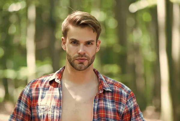 Young man with unshaven facial hair in open plaid shirt natural summer landscape outdoors, skin — Stock Photo, Image