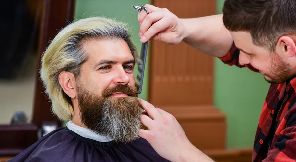 It is just unbelievable. male hairdresser in workshop. bearded man. hair and beard care.