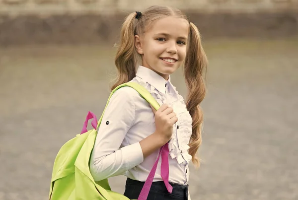 Slim is geweldig. Terug naar school. kind in uniform schooltas dragen. het begrip onderwijs. ontwikkeling van de jeugd. Gelukkig meisje heeft een leuke glimlach. gelukkig kleuter meisje met rugzak in schooltuin — Stockfoto