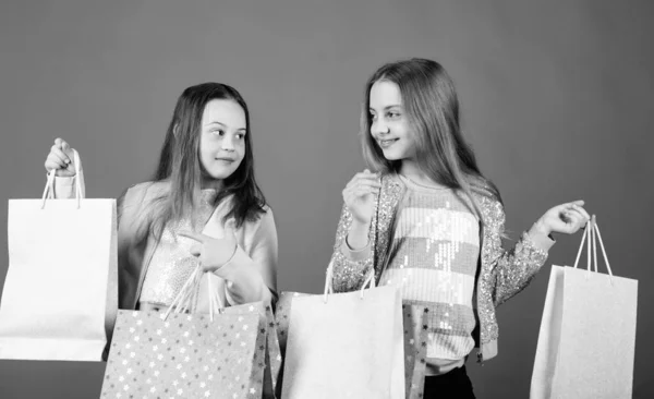 幸せな子供たち。女の子姉妹オンラインショッピングを楽しんでいます。販売と割引。姉妹と家族。購入の節約です。子供のファッション。ショッピングバッグを持つ小さな女の子。ご購入ありがとうございます — ストック写真