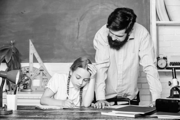 Clases privadas. Haciendo papeleo de tareas caseras. Niño cansado estudio desmotivado aprender. Educar en casa con padre. Habilidades pedagógicas. Profesora de escuela y colegiala. Hombre barbudo pedagogo. Pedagogo estricto —  Fotos de Stock