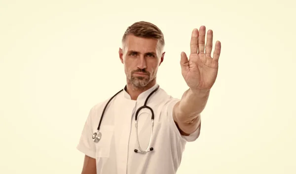 Detener el gesto pandémico de coronavirus del hombre maduro terapeuta con fonendoscopio en uniforme aislado en blanco, covid 19 — Foto de Stock