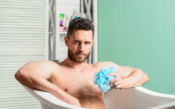 Man tvätta muskulös kropp med skum svamp. Macho attraktiv naken kille. Sexig man i badrummet. Tvätta av skummet med vatten noggrant. Sex och avslappning koncept. Macho naken i badkaret. Sexig verklighet — Stockfoto