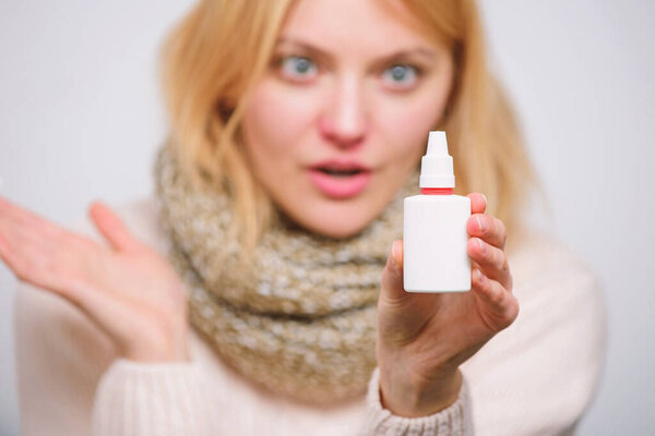 Being good for sinus health. Nasal spray for sick girl with runny nose. Cute woman nursing nasal cold or allergy. Treating common cold or allergic rhinitis. Ill woman spraying medication into nose