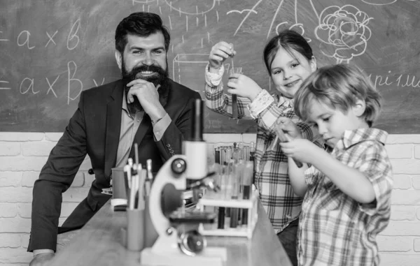 Små barn lär sig kemi i skolans laboratorium mikroskop experimentanteckningar. Mikroskop optiskt instrument i naturvetenskapliga klassrummet. Tillbaka till skolan. utveckling av barn. Att leva i den digitala tidsåldern — Stockfoto