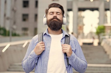 Modern hayat. Şehir merkezinde yürüyen kulaklıklı bir adam. Müzik dinliyordum. Sırt çantası olan yakışıklı bir hippi. İyi ses. İşe günlük rota. Boş sokaklarda yürüyorum. Müzikle baş başa