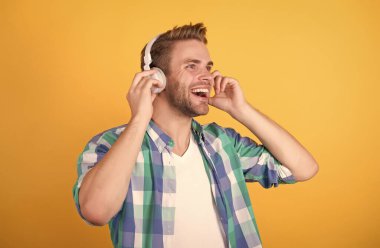 Mutluluk iyi müziktir. Mutlu adam kulaklıkla müzik dinliyor. Yeni teknoloji. Modern hayat. Eğlence ve eğlence. Karaoke kulübü