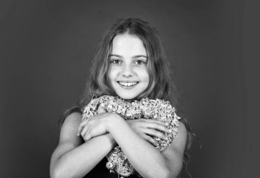 Sevimli kız eğleniyor. Romantik bir ruh hali. Mutlu çocuk kalbini kırmızı arka planda tut. Sevgi ve ilgi tatili. Pembe kalpli küçük bir kız. Kalp şeklinde dekoru olan sevgililer günü. Sevildiğimi hissetmek. Güzel bebek.