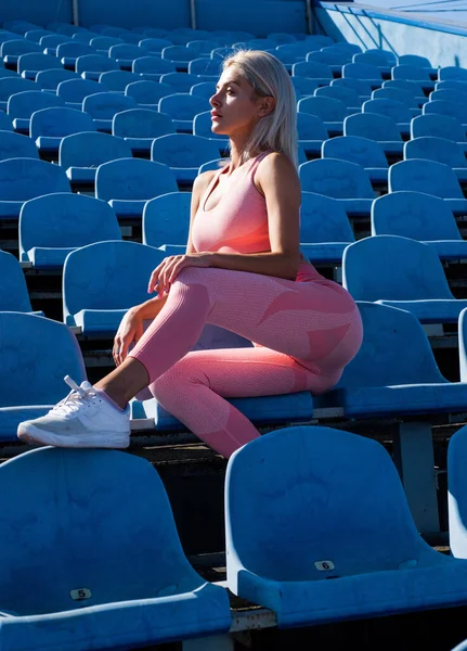 Athletische Frau in Fitnessbekleidung entspannen im Stadion, entspannen — Stockfoto