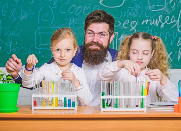 Tanítási idő. Az iskolás lányok kémcsöveket tartanak a tanár vezetésével. Iskolás gyerekek kísérleteznek a természettudományi tanteremben. Tudományos laboratórium az iskolának és az oktatásnak. Laboratórium az általános iskolában — Stock Fotó