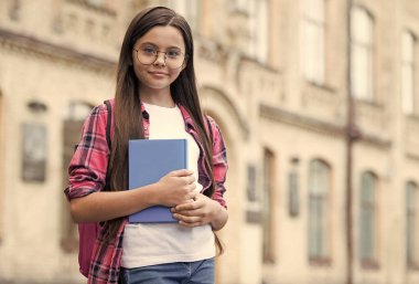 Bilgini zenginleştir. Küçük çocuk kitabı dışarıda tutuyor. Okula dönelim. Bilgi toplama günü. 1 Eylül. Okul kütüphanesi. İlkokul eğitimi. Başla. Bilginin başladığı yerde, uzayı kopyala