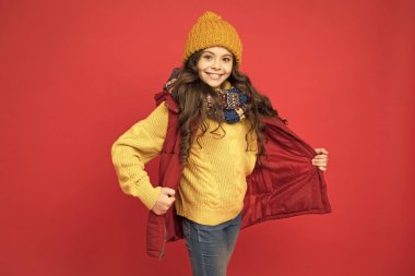 Uzun saçlı, kalın elbiseli, kış tarzında neşeli bir kız.