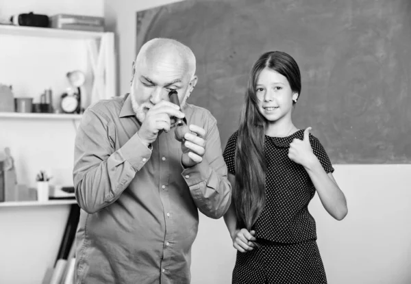 Educação escolar. amostra biológica. professor maduro olhar através de tubo de lupa em cal. menina pequena explorar fatia de frutas. Escola. Microscopia. Análise e síntese. expandir o conhecimento do mundo — Fotografia de Stock