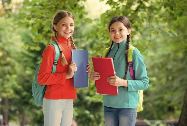 Schoolmeisjes met rugzakken en lesboeken in het bos, het verkennen van de natuur concept — Stockfoto
