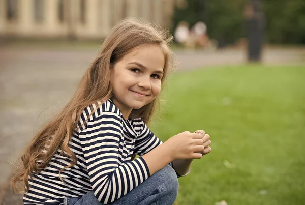 Låter ditt barn har brytt sig bättre. Glada barn sitter på hemsökelser utomhus. Lilla flicka barn i avslappnad stil. Modetrend. Trendig stil. Barnomsorg och barndom. Internationella barnens dag — Stockfoto