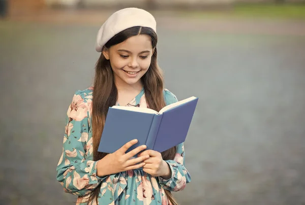 Menina estudante ler livro ao ar livre, escola de boas maneiras conceito — Fotografia de Stock