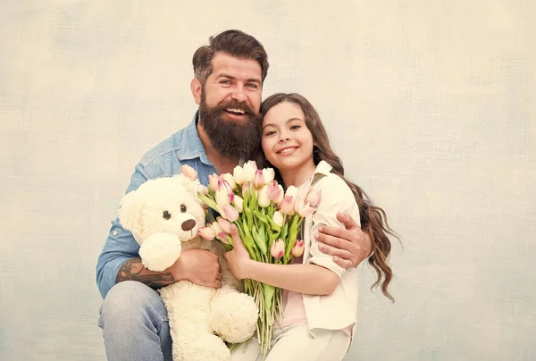 Familia feliz de padre e hija abrazo con primavera tulipán ramo de flores y peluche juguete, 8 marzo — Foto de Stock