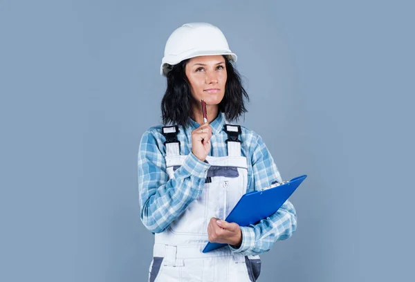 Your one stop source. mechanic girl in protective hardhat. building and construction. professional manual worker. technician working folder planning documents. safety uniform