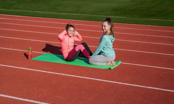 Ευτυχισμένη τακτοποίηση έφηβα κορίτσια κάνουν καταστάσεις σωματική εκπαίδευση στον αθλητισμό κομμάτι, γυμναστήριο. — Φωτογραφία Αρχείου