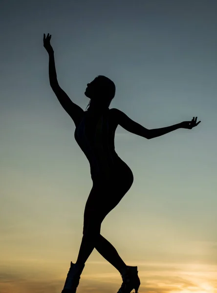 在暮色中跳舞的女芭蕾舞演员的轮廓在黄昏的天空中，芭蕾舞的轮廓 — 图库照片