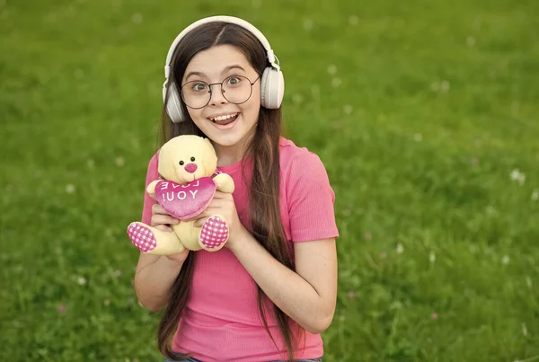 Jeu d'été. Happy girl jouer avec ours en peluche sur l'herbe verte. Jeux d'enfance à jouer. Activité de plein air. Développement et croissance de l'enfant. Jouer avec des jouets. Magasin de jouets. Jouer pour développer l'imagination — Photo