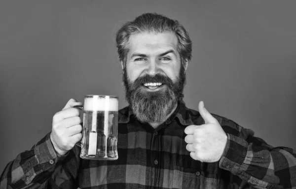 Refresca o teu espírito. Um homem barbudo bebe cerveja. Um pub de cerveja. Barman Bar. Homem segura caneca de cerveja. Hipster no balcão do bar. A divertir-me. Bebida alcoólica. Um hipster moderno a embebedar-se. Bebida de boas vindas — Fotografia de Stock