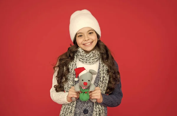Надзвичайно щаслива дівчинка з довгим волоссям носить теплий одяг і тримає подарунок різдвяну іграшку після покупок, щасливе дитинство — стокове фото