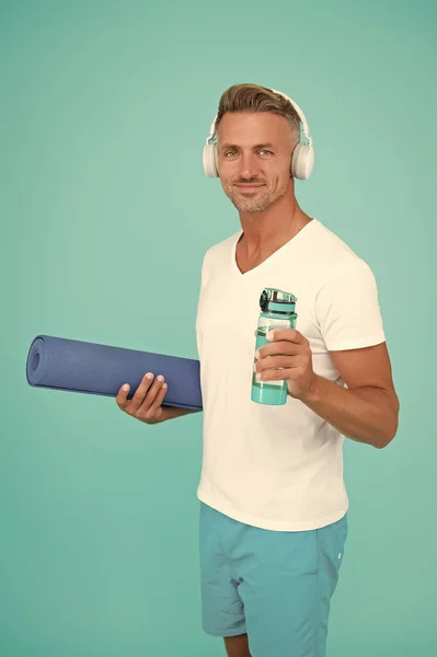 Homme musculaire faisant de l'exercice à la maison avec tapis de sport, concept de mode de vie sain — Photo