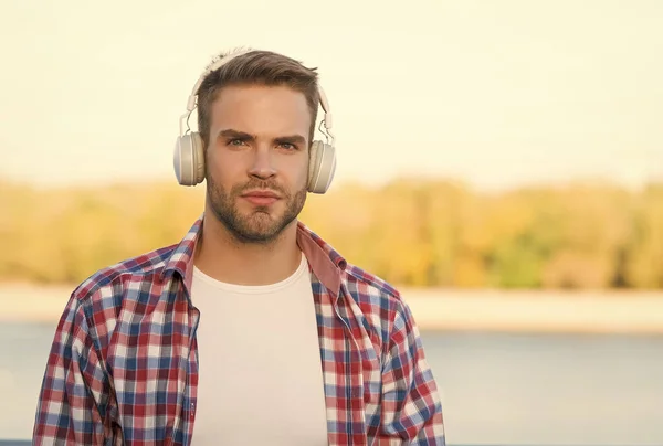 Educação à Distância. estilo musical. conceito de aprendizagem electrónica. qualidade do som. dispositivo sem fio inovador. um tipo sem barba com auscultadores estéreo. moda hipster casual masculina. homem no fone de ouvido ouvir música — Fotografia de Stock