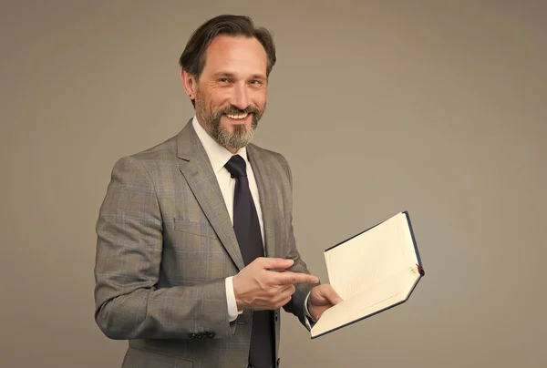 Hombre feliz en traje con libro. contable mantiene registros contables. tomando notas en el cuaderno. Vea la lista de tareas pendientes en su diario. Profesor universitario. hombre maduro leyendo literatura de negocios —  Fotos de Stock