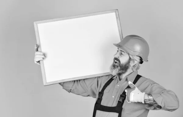 Architekt zeigt Projekt. Professioneller Reparateur. Optische Umrisse. Problemlösungskonzept. Der bärtige Bauarbeiter. Planen Sie Reparaturarbeiten. Reparateure halten Whiteboard-Kopierraum bereit. Hübscher Reparateur — Stockfoto