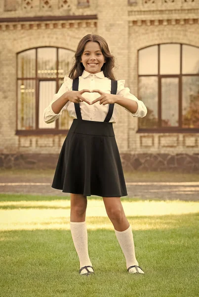 Tan individual como tú. felicidad infantil. Moda vintage para niños. Pequeña estudiante en la hierba. de vuelta a la escuela. chica que parece inteligente e inteligente. colegiala feliz en uniforme elegante. símbolo del amor —  Fotos de Stock