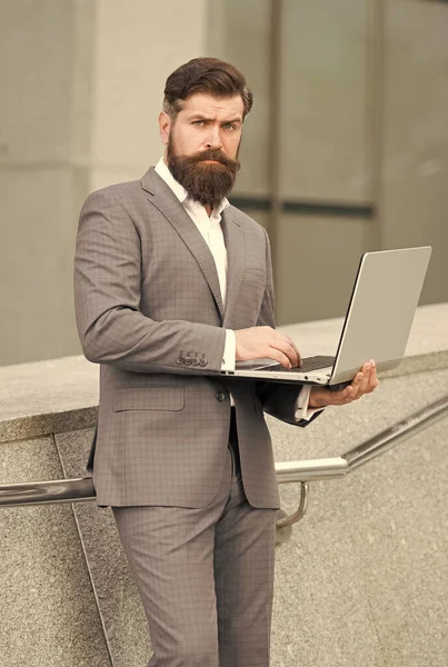 オンラインビジネスを運営している。髭の男は屋外でオンラインで働いている。デジタルマーケティング。スタートアップだ。フリーランスの仕事だ。現代の技術。ビジネスコミュニケーション。ネットサーフィン。ビデオ会議。フォーマルファッション — ストック写真
