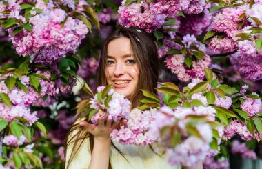 Bahar geldi. Çiçek kokusu, alerji. Bahar çiçeğindeki kadın çiçek açar. Kiraz çiçekli kız. Sakura ağacı çiçek açıyor. Cilt bakımı ve spa. Cilt için doğal kozmetik. Doğal yaz güzelliği