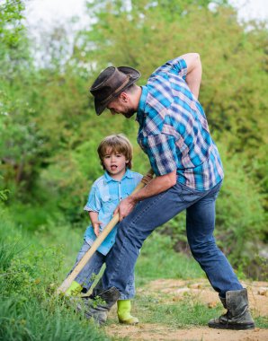 Hazineler için macera avcılığı. Bahçede çalışan küçük bir yardımcı. Doğada sevimli bir çocuk kürekle eğleniyor. Hazineleri bul. Kürekle hazine arayan küçük bir çocuk ve babası. Mutlu çocukluk