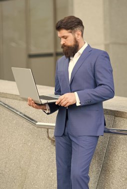 Resmi takım elbiseli sakallı adam internetteki açık hava ve e-postayı kullanarak bilgisayardaki elektronik postaları kontrol et.