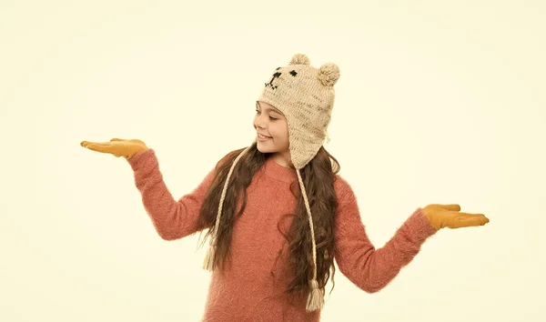 Feliz actividad infantil. niña en patrón divertido sombrero de orejera. vacaciones de invierno maravilla. niño sombrero de punto aislado en blanco. clima frío de invierno. ropa de abrigo y accesorios de moda para niños —  Fotos de Stock