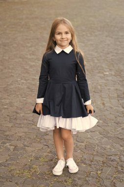 Mutlu küçük çocuk okul üniforması giyiyor. Açık hava tarzında, moda.