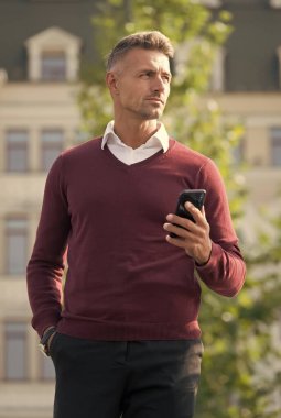 Mesaj gönder. Taşınabilir yaşam tarzı. Çevrimiçi iletişim. Modern iletişim. İş adamı cep telefonunu tutar. Telefonu olan yakışıklı bir adam. İnternet bağlantısı. Kullanışlı bir uygulama. İş iletişimi