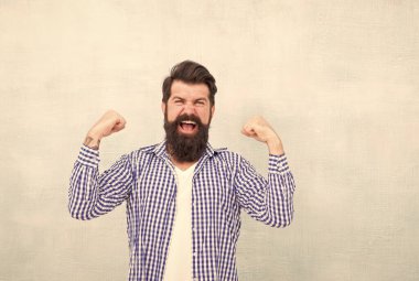 Başarının gücü. Mutlu hipster kollarını yukarı kaldırır ve parmaklarını sıkar. Sakallı adam zaferi kutluyor. Berber dükkanı. Berber dükkanı. Kuaför salonu. Sıradan bir tarz. Moda modası. Güç ve hakimiyet