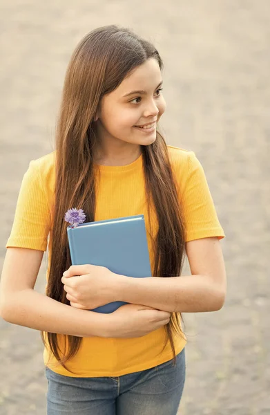 Ela tem o livro que precisa. Feliz livro infantil ao ar livre. Cute bookworm usar cabelos longos em estilo casual. Biblioteca da escola. Literatura infantil. Educação de alfabetização. Ler é o seu hobby — Fotografia de Stock