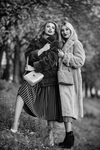 Stay warm and fashionable. Women wear furry coats. Winter clothes. Wardrobe  for cold weather. Girls enjoy cozy fancy chic coats. Natural wool sheepskin  coats. Fur shop. Backpack fashion accessory Stock Photo by ©