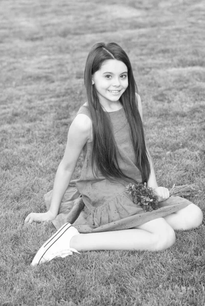 Dívka modré šaty relaxovat zelené pole s čerstvými chrpy, Happy dětství koncept — Stock fotografie
