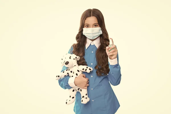 带着玩具的小女孩戴着医用口罩，在白色、手部清洁剂上与COVID-19隔离 — 图库照片