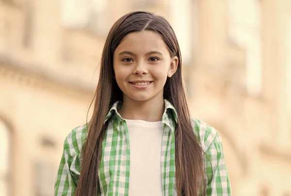 Criança pequena feliz com sorriso de cabelo longo no estilo de moda casual urbano ao ar livre, infância — Fotografia de Stock