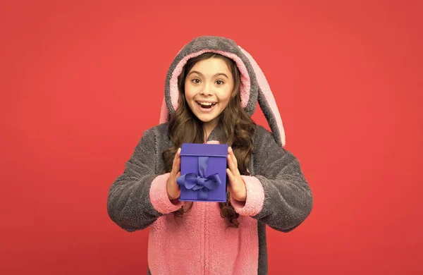 Магазин и торговый концепт. Девочка-подросток в пижаме. счастливый ребенок носит кроличью кигуруми и держать коробку с сюрпризами. подарки и подарки. домашний аксессуар сувенир. чувствовать себя отдохнувшим и счастливым — стоковое фото
